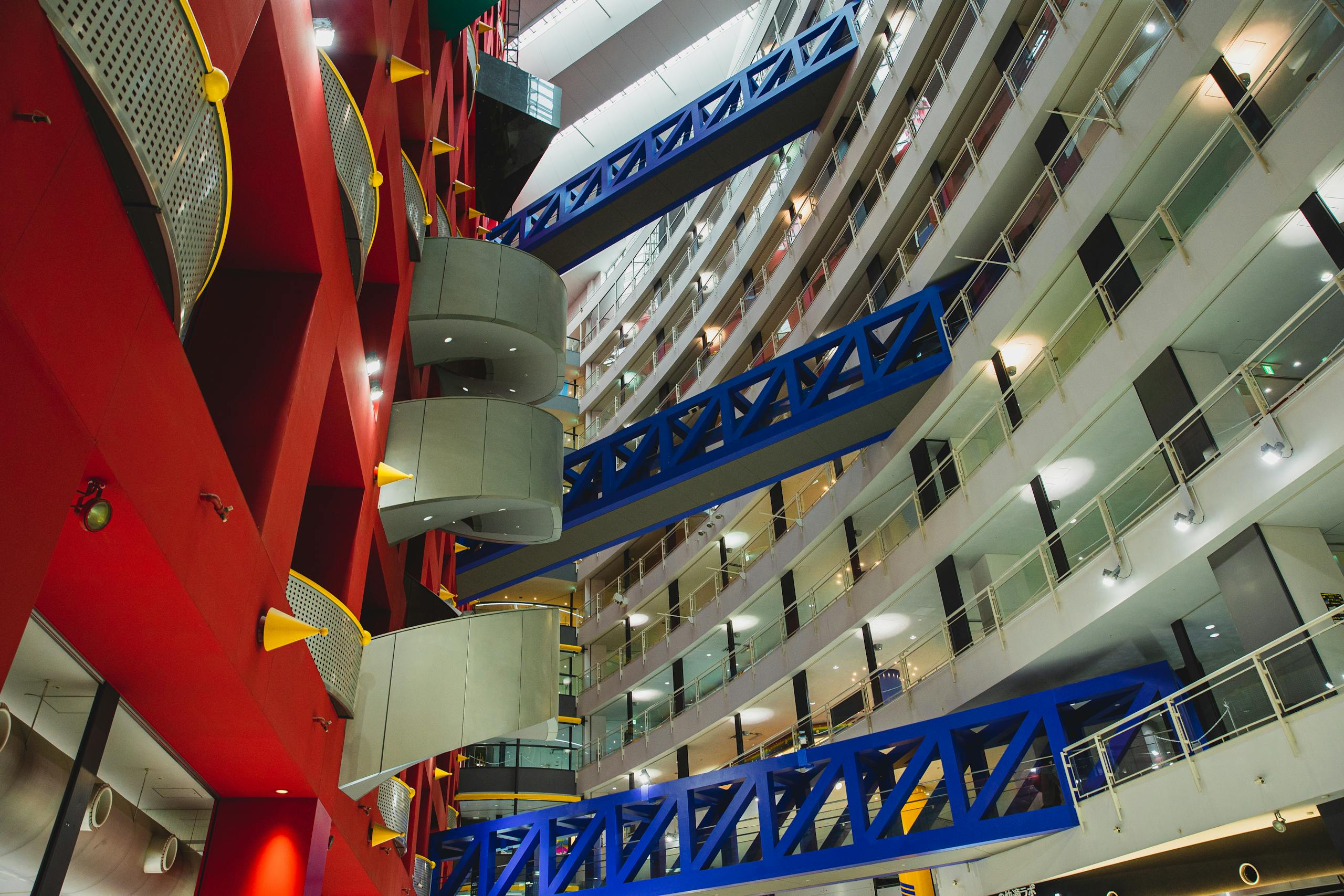 Dynamic low-angle view of a modern, multistory shopping mall interior with vibrant colors and geometric design.