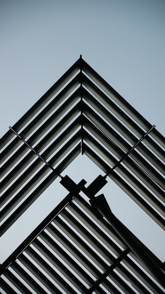 Vertical shot of a symmetric metal structure with a clear blue sky background.